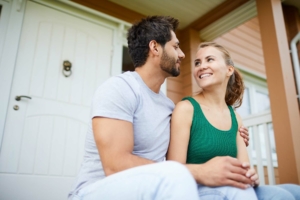 Happy couple sitting on their front porch